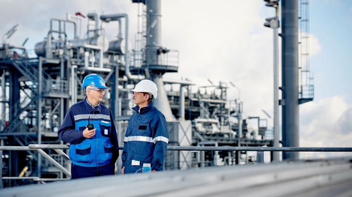 Technische Experten vor einer Raffinerie