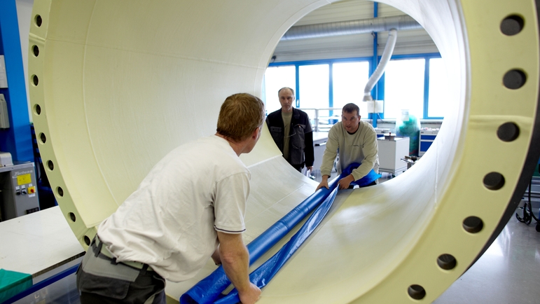Endress+Hauser Flow France, Cernay, Männer schauen durch Durchflussmessgerät mit grossem Durchmesser
