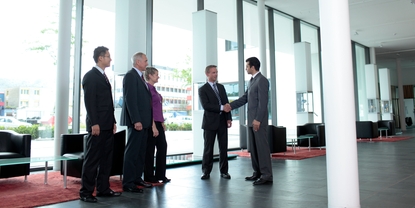 Mitarbeiter und Kunde beim Händeschütteln in der Lobby von Endress+Hauser