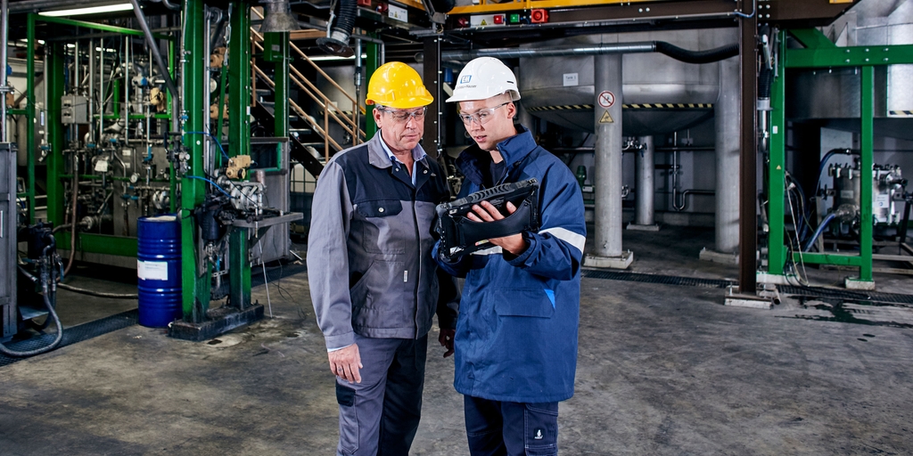 Mitarbeiter von Endress+Hauser mit einem Kunden in einer agrochemischen Anlage beim Einsatz des Field Xpert