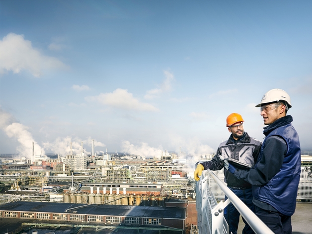 Zwei Ingenieure sehen sich eine große Industrieanlage an.